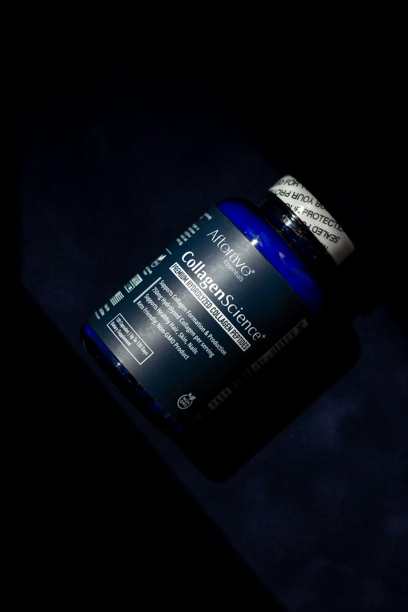 Blue collagen supplement bottle on a dark background, emphasizing skin health benefits.