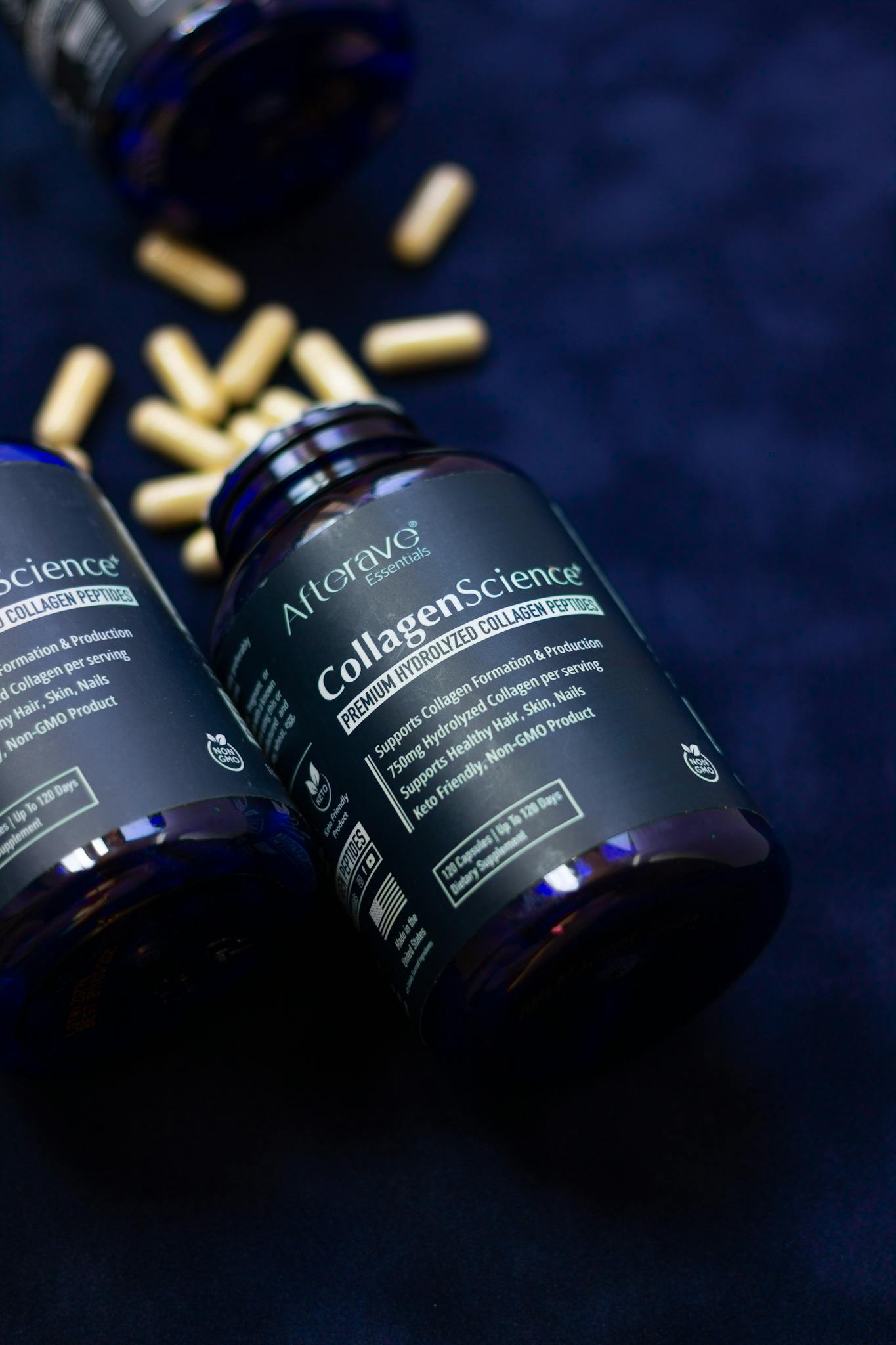 Bottles of premium hydrolyzed collagen supplements and capsules on a dark background.